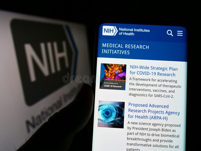Person holding cellphone with webpage of US agency National Institutes of Health (NIH) on screen with logo. royalty free stock images Person holding cellphone with webpage of US agency National Institutes of Health (NIH) on screen with logo. royalty free stock images
