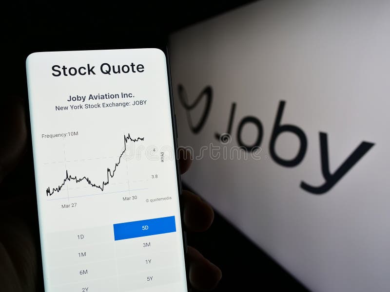 Stuttgart, Germany - 03-31-2023: Person holding cellphone with website of US eVTOL company Joby Aviation on screen in front of business logo. Focus on center of phone display.