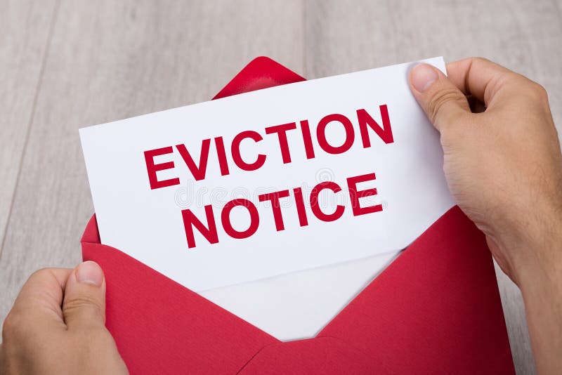 Close-up Of A Person`s Hand Holding Eviction Notice In Red Envelope. Close-up Of A Person`s Hand Holding Eviction Notice In Red Envelope