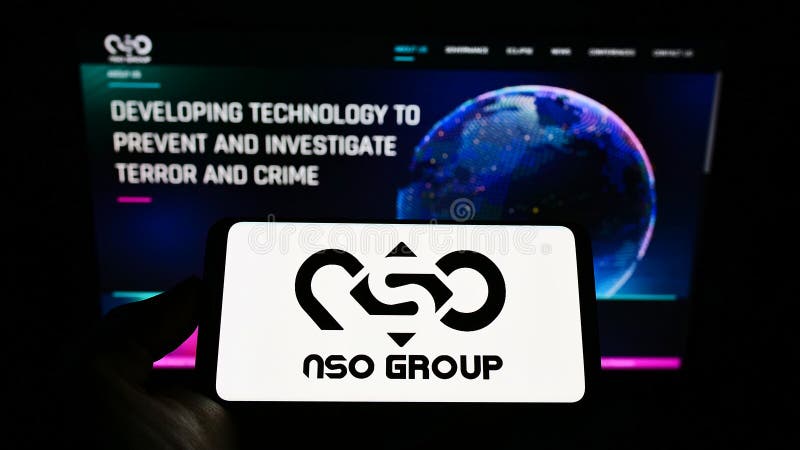 Person holding mobile phone with logo of technology company NSO Group Technologies Ltd. on screen in front of web page. stock photos
