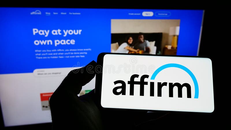 Person holding mobile phone with logo of US financial technology company Affirm Holdings Inc. on screen in front of webpage.