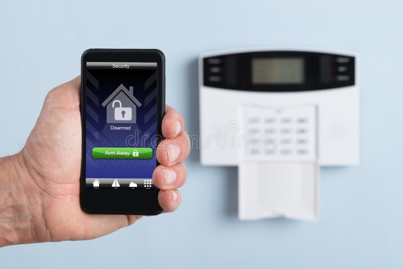 Person holding remote control of security system stock photos