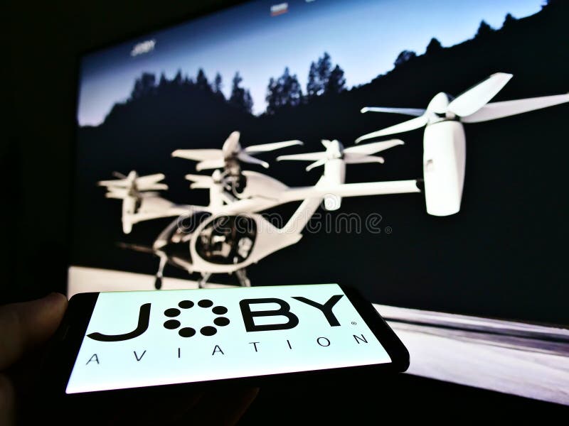 Person holding smartphone with logo of startup and aerospace company Joby Aviation (air taxi) on screen.