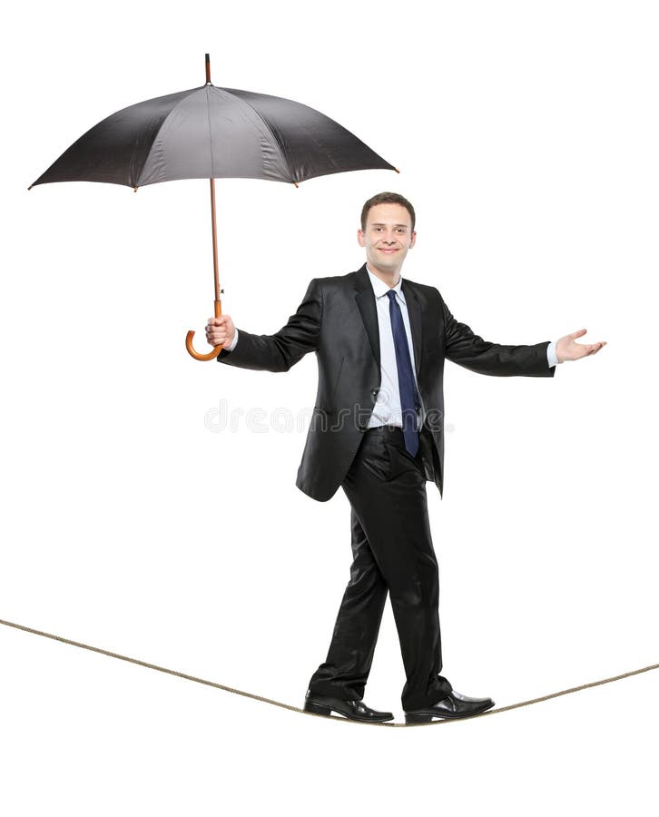 A person holding an umbrella and walking on a rope royalty free stock images A person holding an umbrella and walking on a rope royalty free stock images