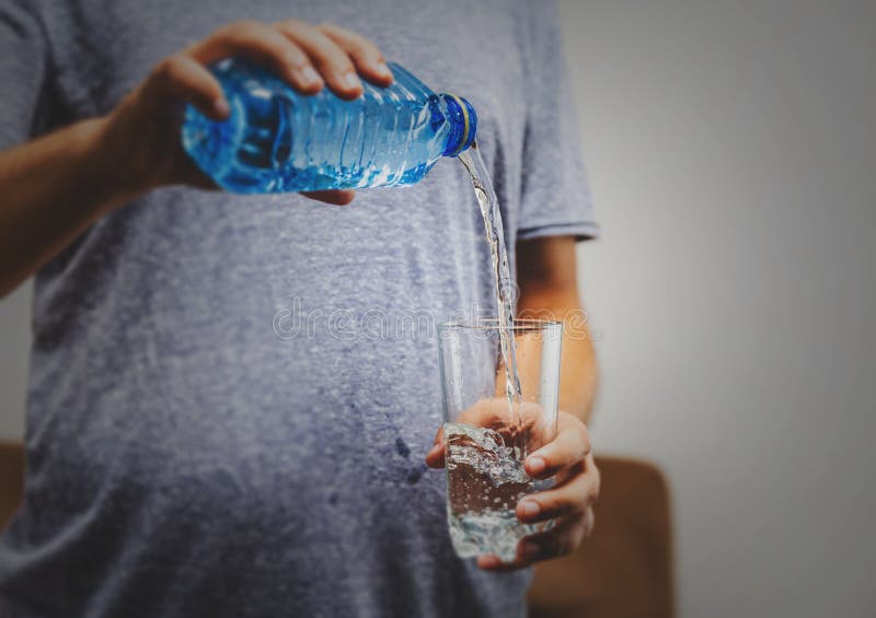 person pouring water in glass over white background