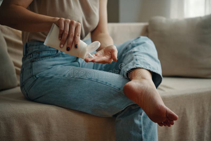 Applying Lotion on Relaxed Bare Legs in Cozy Home Setting stock images