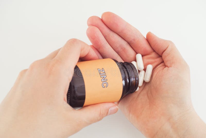 Person taking Zinc pills out of a bottle