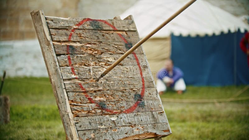 A person throwing a spear in the wooden target - gets in the circle area