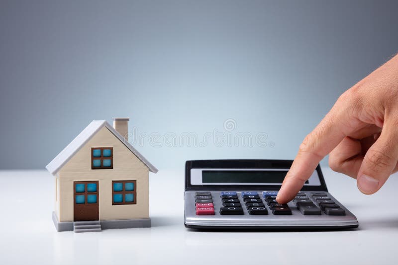 Person Using Calculator Near House Model royalty free stock photography