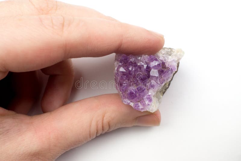 The person who holds the fingers crystals of purple amethyst. stock photo The person who holds the fingers crystals of purple amethyst. stock photo
