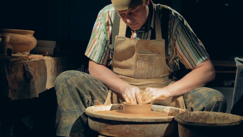 Man potterist making bowl on a potters wheel from clay in a