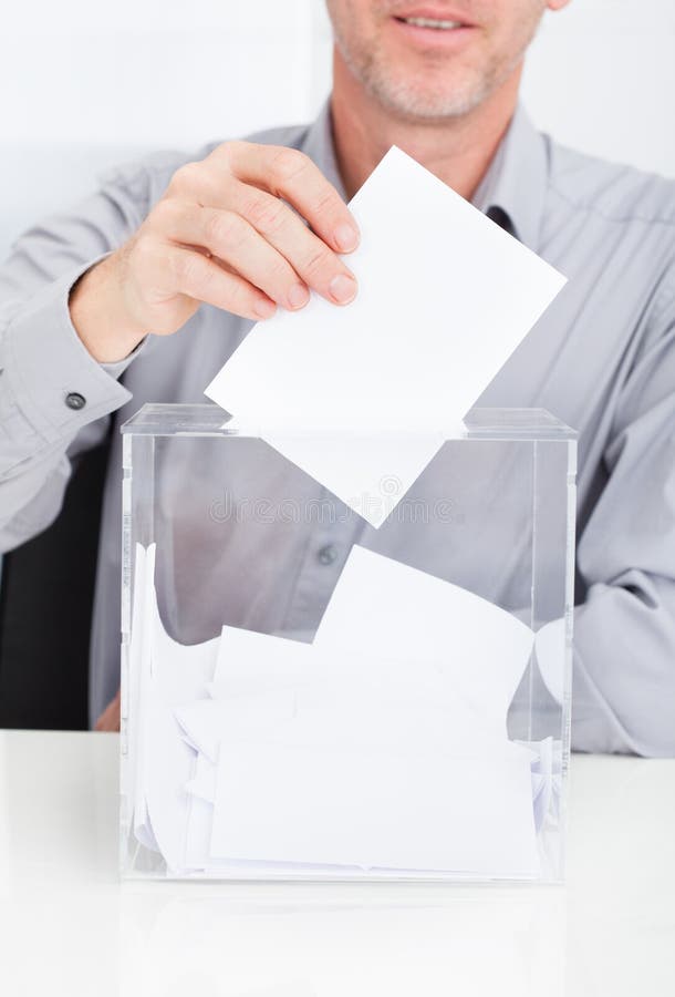 Persona che inserisce voto in scatola immagine stock Persona che inserisce voto in scatola immagine stock