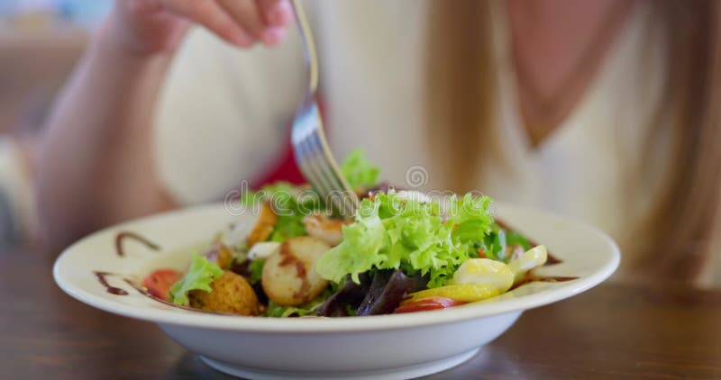 Persona comiendo ensalada de verduras frescas con pollo asado en un plato blanco metrajes