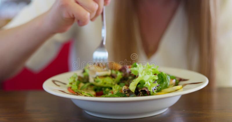 Persona comiendo ensalada de verduras frescas con pollo asado en un plato blanco metrajes