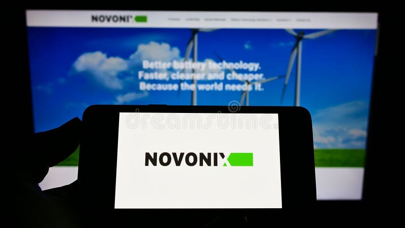 Persona con teléfono móvil con el logotipo de la compañía australiana de baterías novonix limitada en pantalla frente a la página imagenes de archivo