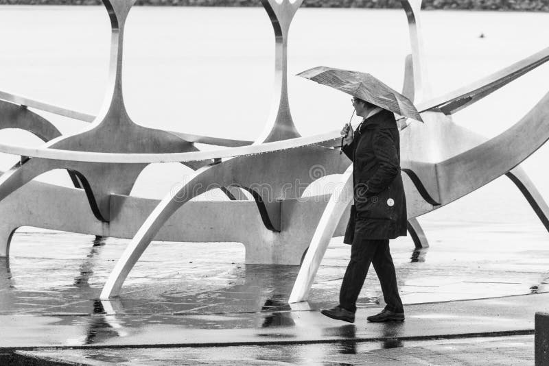 Persona con umbrela cerca de Solfarid - viajero de Sun en Reykjavik fotografía de archivo Persona con umbrela cerca de Solfarid - viajero de Sun en Reykjavik fotografía de archivo