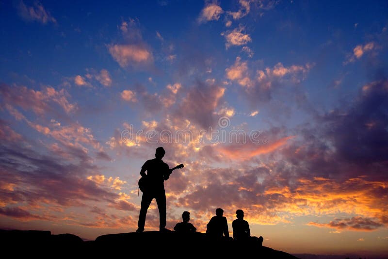 Persona feliz de la gente de los amigos de la silueta que se divierte que se sienta encima de una montaña de la colina de la roca fotografía de archivo Persona feliz de la gente de los amigos de la silueta que se divierte que se sienta encima de una montaña de la colina de la roca fotografía de archivo