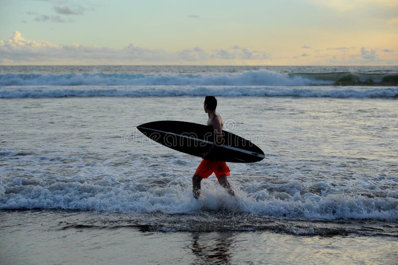 Persona que practica surf con el tablero fotografía de archivo Persona que practica surf con el tablero fotografía de archivo