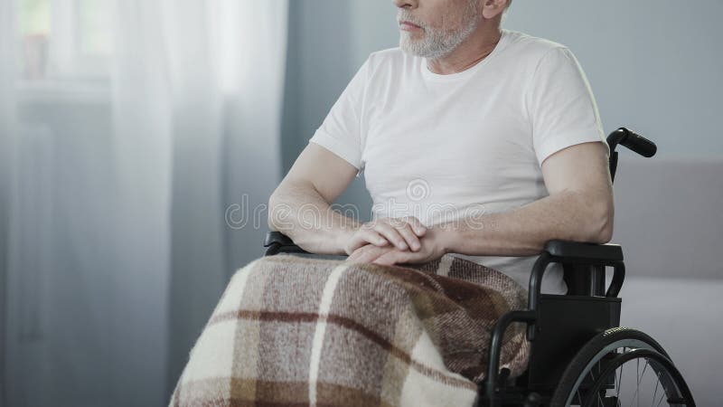 Persona senior malata che si siede in sedia a rotelle, pensante alla vita, supporto di bisogni dell'uomo immagine stock libera da diritti Persona senior malata che si siede in sedia a rotelle, pensante alla vita, supporto di bisogni dell'uomo immagine stock libera da diritti