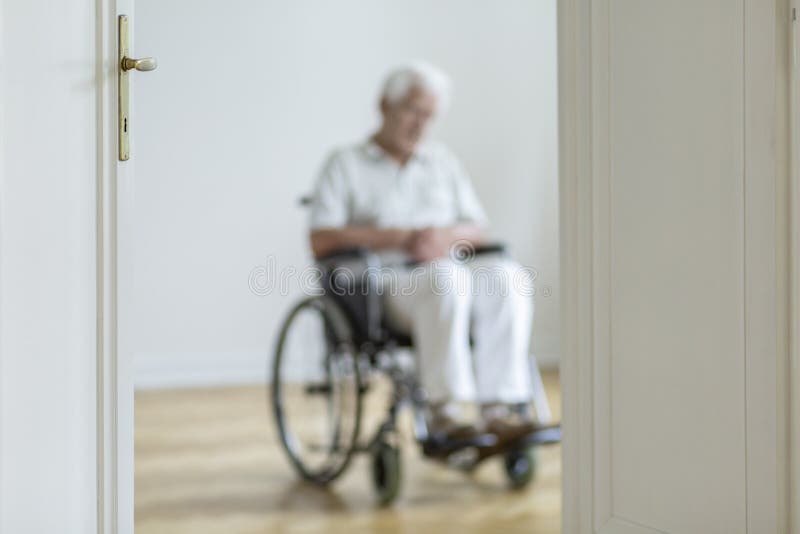 Persona vaga in una sedia a rotelle nei precedenti da solo a casa