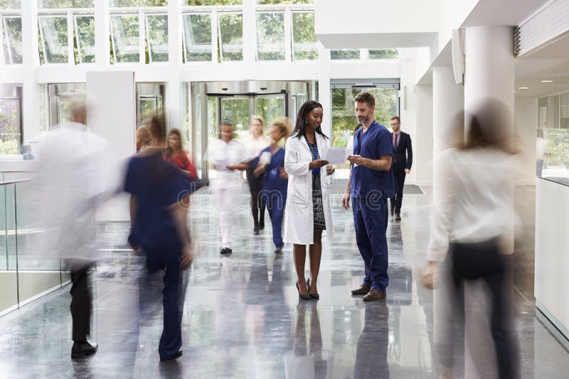 Personal i upptaget lobbyområde av det moderna sjukhuset
