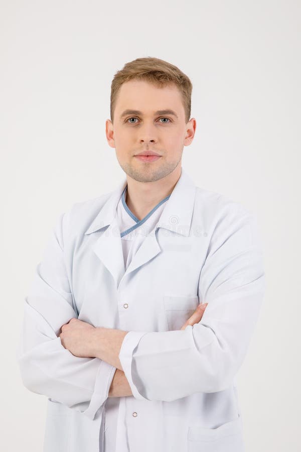 Personal m?dico El doctor comprensivo joven se coloca aislado en un fondo blanco vestido en un uniforme para los doctores imágenes de archivo libres de regalías Personal m?dico El doctor comprensivo joven se coloca aislado en un fondo blanco vestido en un uniforme para los doctores imágenes de archivo libres de regalías
