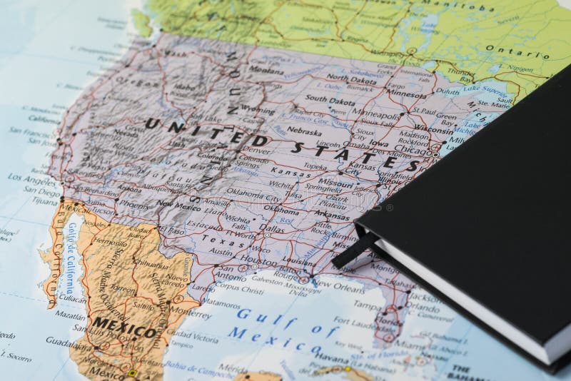 Personal planner notes of a traveller planning a trip to United States of America over a closeup map of USA.