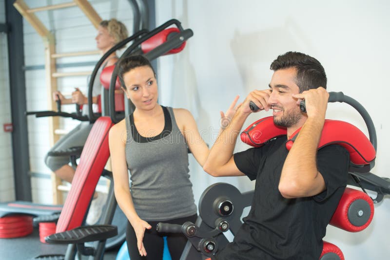 Personal Trainer Instructing Trainee In Gym Stock Photo Image Of