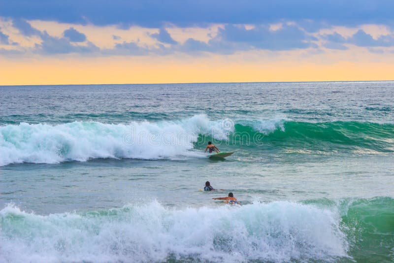 Personas Que Practica Surf En Las Tablas Hawaianas En Las Ondas Imagen