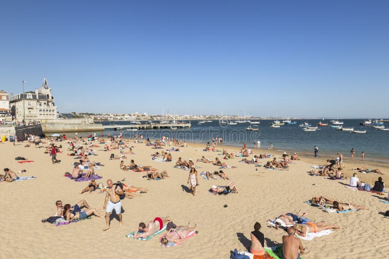 Personas Tomando El Sol En Una Playa En Cascais Imagen de archivo