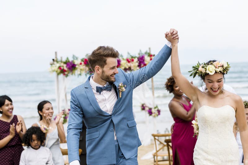 Persone appena sposate allegre a cerimonia di nozze della spiaggia