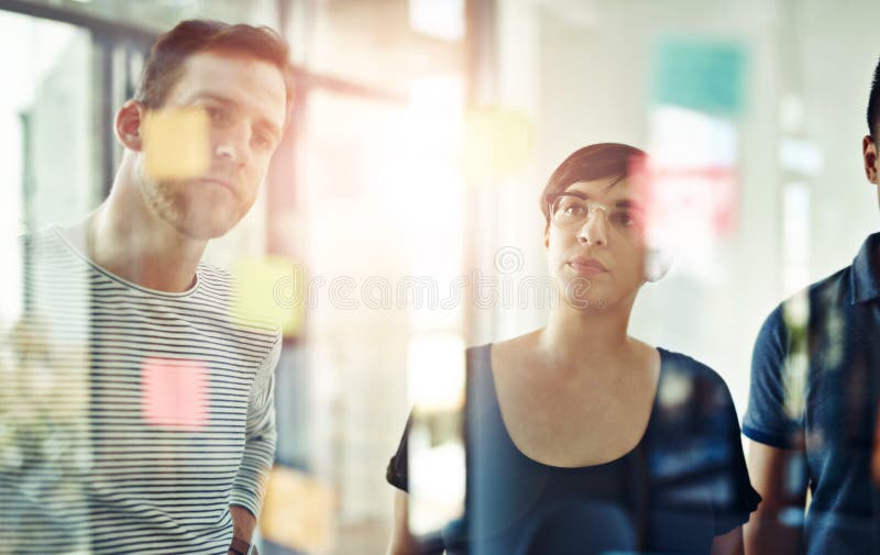 Persone d'affari che pensano con il vetro in ufficio per la pianificazione di team idee creative e per la scadenza prevista. grupp immagine stock