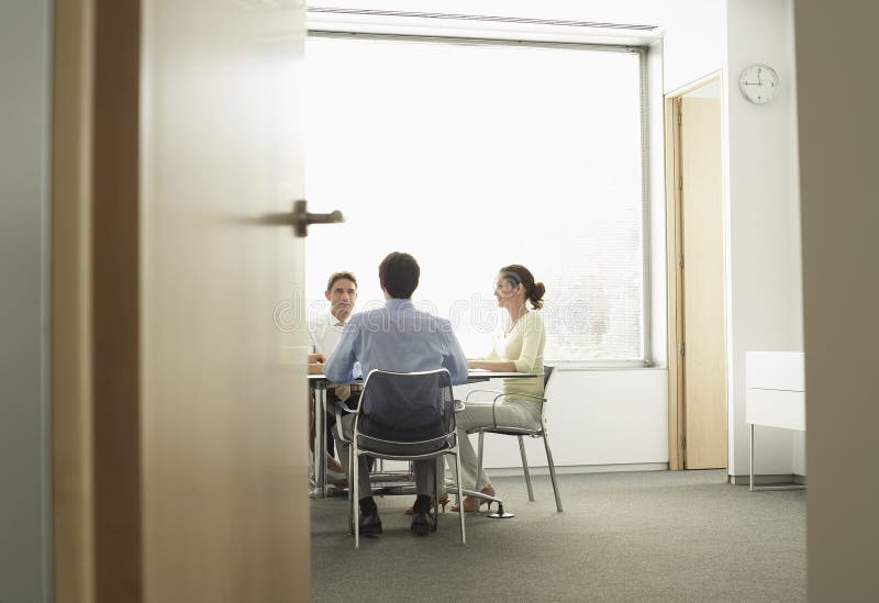 Persone di affari che hanno una riunione in sala del consiglio immagini stock Persone di affari che hanno una riunione in sala del consiglio immagini stock