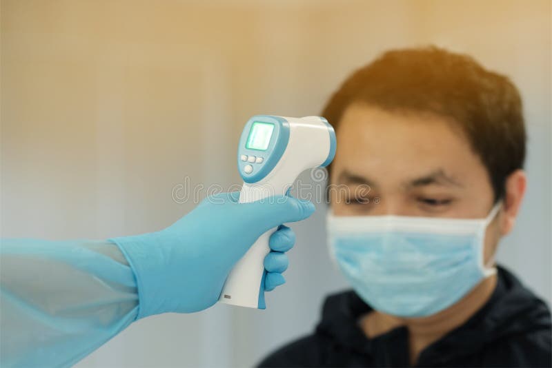 Personel medyczny stosuje termometr czołowy podczerwieni do kontroli temperatury ciała covid19 koncepcja ogniska
