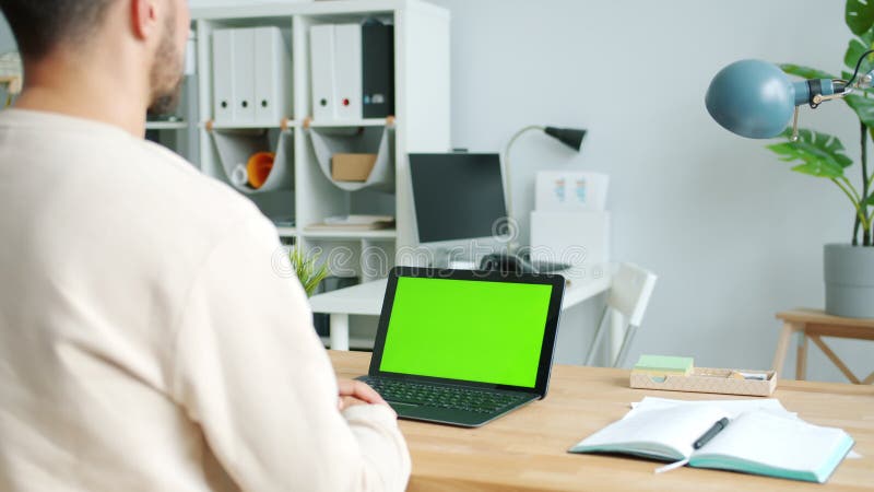 Personne d'affaires regardant l'ordinateur portable à clé chroma à écran vert travaillant dans un bureau moderne banque de vidéos