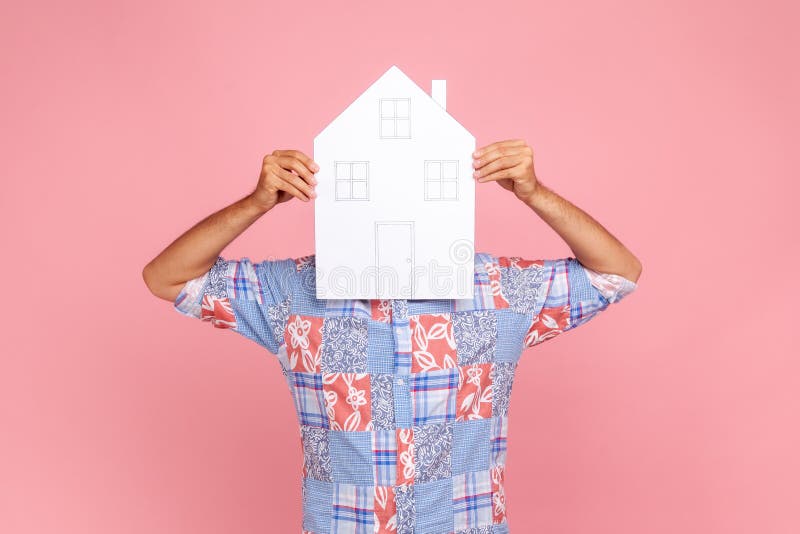Personne inconnue homme en bleu casual chemise recouvrant son visage avec grand papier maison rêve de logement propre domaine photos stock