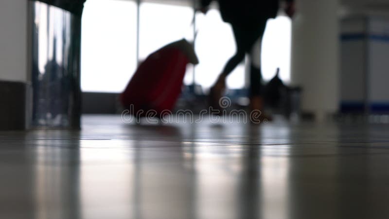 Personnes anonymes marchant par un terminal d'aéroport avec des valises, des sacs et des bagages