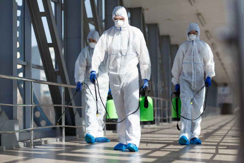 People in virus protective suits and mask disinfecting buildings of coronavirus with the sprayer,. People in virus protective suits and mask disinfecting buildings of coronavirus with the sprayer,