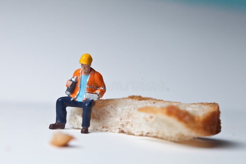 Personnes miniatures dans l'action avec un morceau de pain