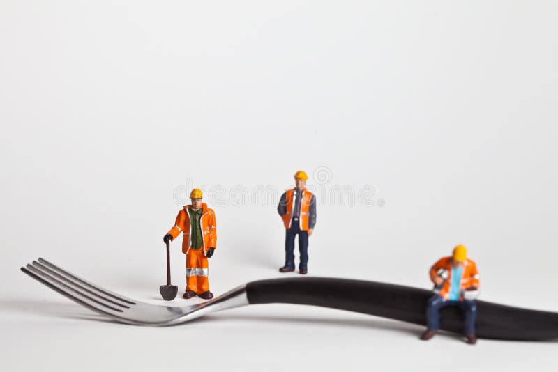 Personnes miniatures dans le travailleur d'action sur une fourchette