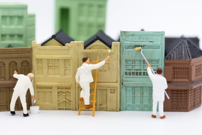 Personnes miniatures : Les travailleurs peignent le bâtiment en ville Utilisation d'image pour le concept d'affaires