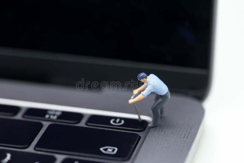 Personnes miniatures : traction de travailleur un bouton d'ordinateur portable de puissance photos stock Personnes miniatures : traction de travailleur un bouton d'ordinateur portable de puissance photos stock