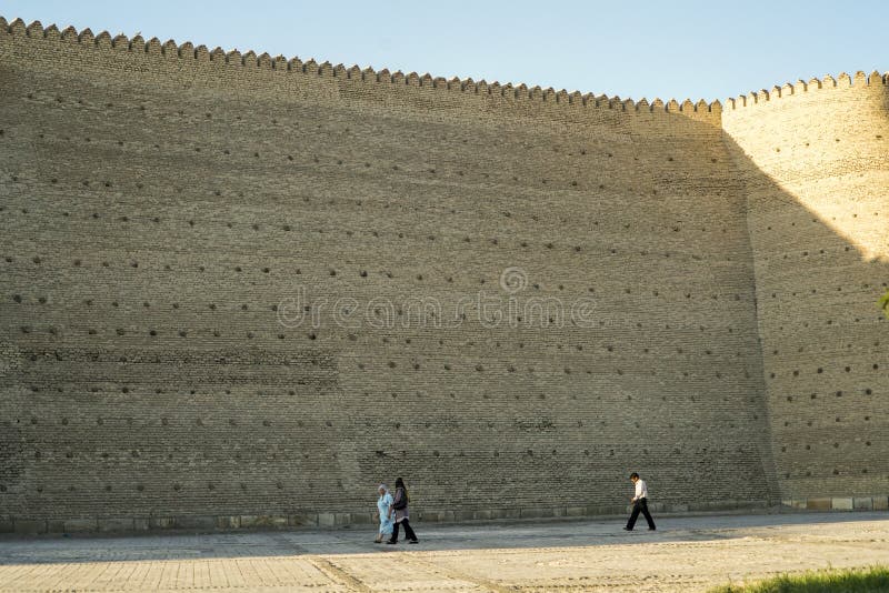 Personnes minuscules par les murs d'arche à Boukhara l'Ouzbékistan photo stock Personnes minuscules par les murs d'arche à Boukhara l'Ouzbékistan photo stock
