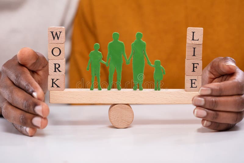 Person Protecting Work And Life Balance With Family Figures Standing Between Them On Seesaw. Person Protecting Work And Life Balance With Family Figures Standing Between Them On Seesaw