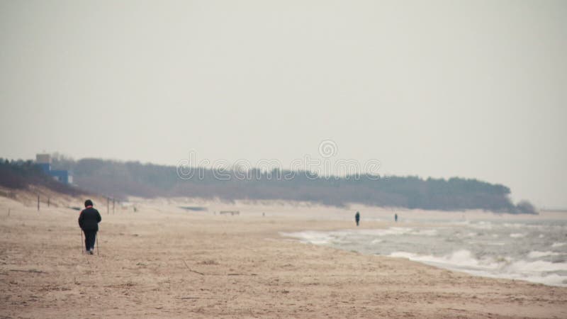 Persoonsrecreatie het noordse lopen op het strand in Palanga, Litouwen