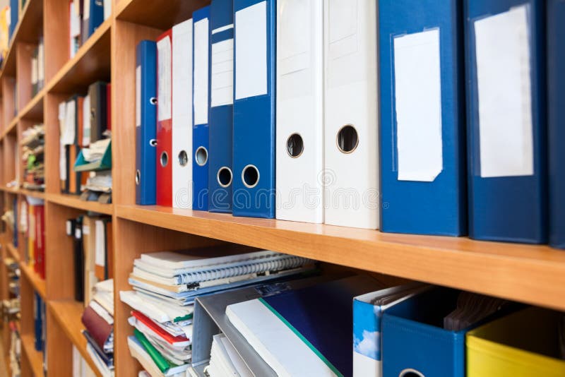 Perspective view at of colourful binders sorted on office shelves, an archive. Perspective view at of colourful binders sorted on office shelves, an archive