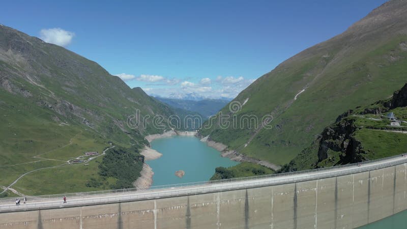 Perspective aérienne du réservoir de Stausee Mooserboden miroir des pentes alpines escarpées banque de vidéos