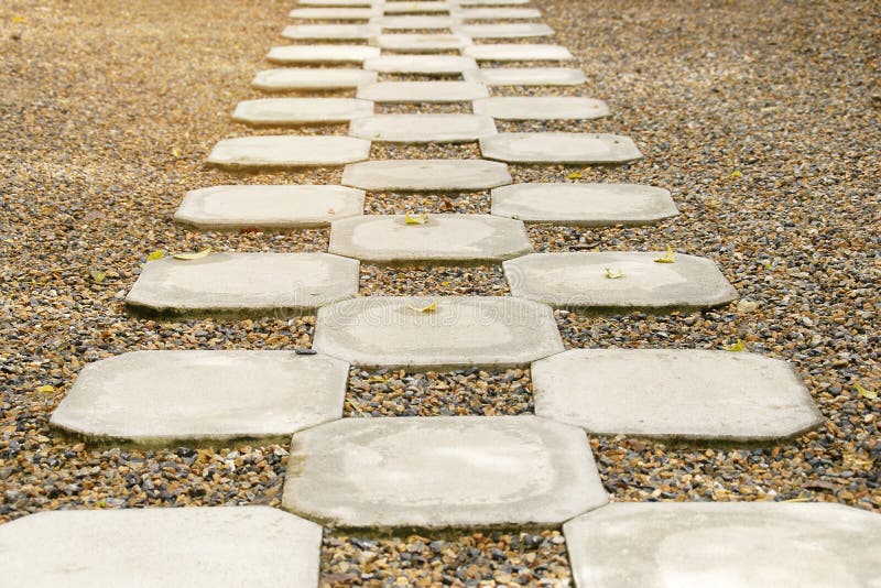 Perspective View Of Cement Block Pathway On Gravel Garden Floor Stock