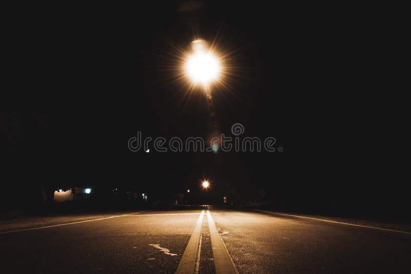 When Driving At Night On A Dimly Lit Street Perspective View Of Lane Lines Of An Old Asphalt Road In A Dark Creepy
