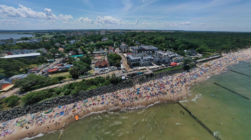 Perspektiv och panoramautsikt för surr flyg- på den soliga stranden med sunbathers med vindskydd och handdukar på havet i tourist royaltyfri foto Perspektiv och panoramautsikt för surr flyg- på den soliga stranden med sunbathers med vindskydd och handdukar på havet i tourist royaltyfri foto